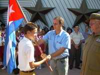 Misael Enamorado, miembro del Buró Político del Partido Comunista de Cuba y su Primer Secretario en la provincia, junto al General de División, Antonio Enrique Lussón, Héroe de la República de Cuba, abanderaban la Caravana entregando la Enseña Nacional al niño Ricardo Hodelin Fuentes, el Jefe de la Columna